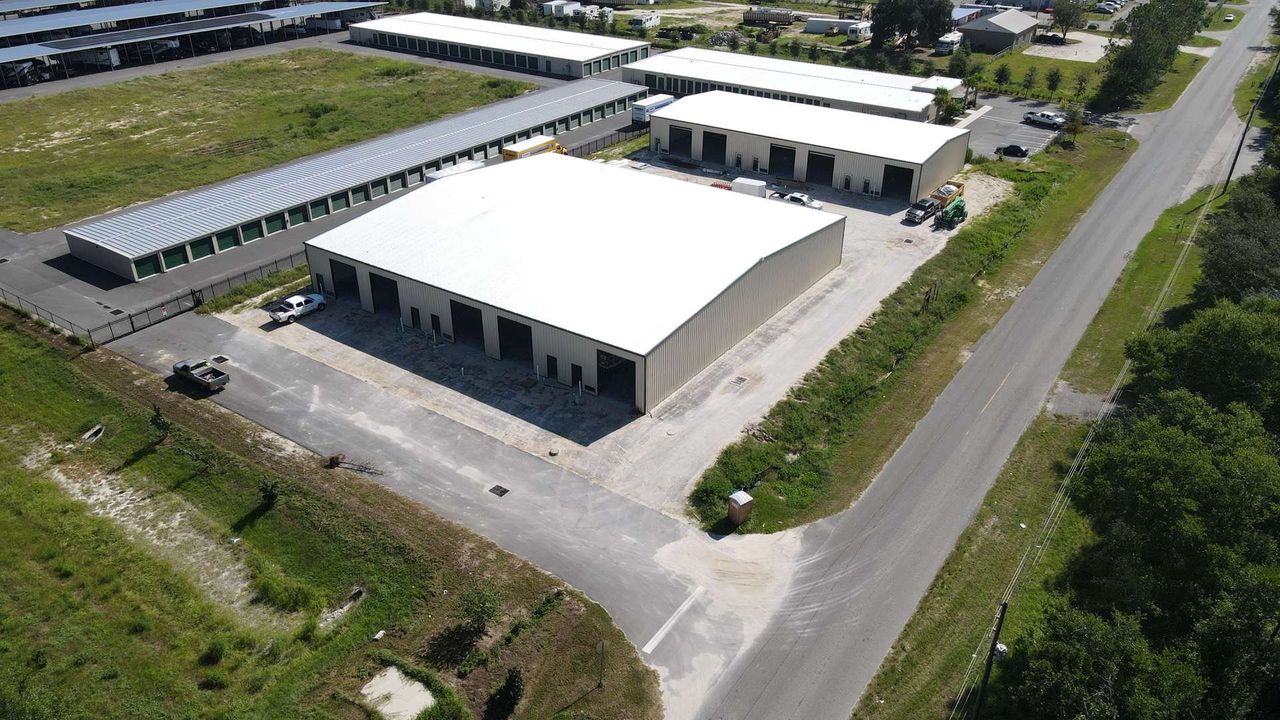 Aerial view of new metal flex buildings with overhead doors and a truck court in Leesburg, Florida.